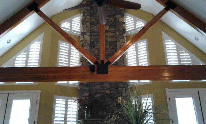 Angled windows on tan wall with stone divider.